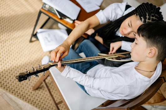 Boy with Adult learning to play guitar