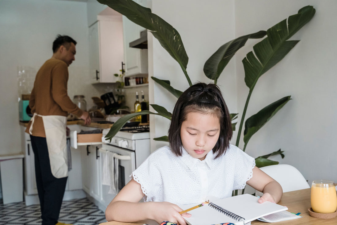 Father in kitchen while child doing homework