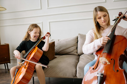 Girl playing cello and making a funny face at teacher
