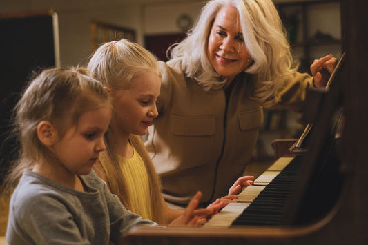 Girls at piano with grandmother