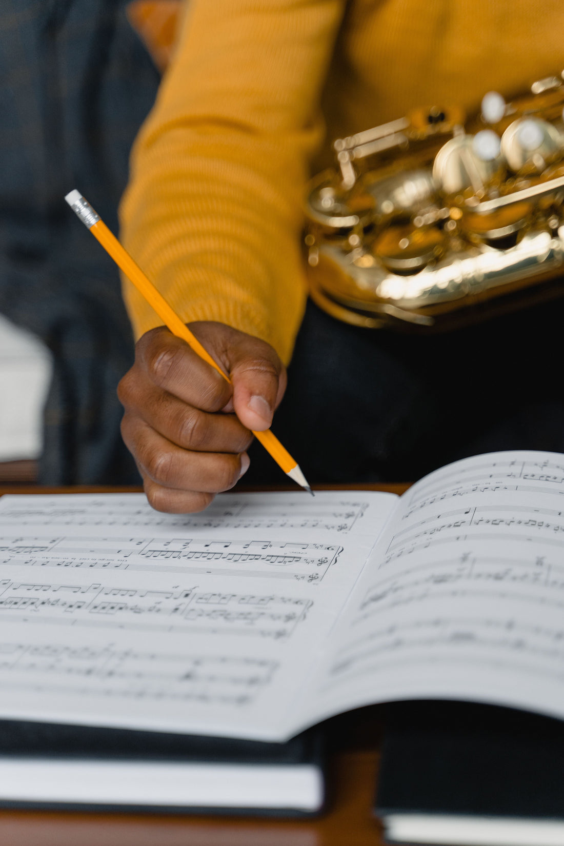 Student with saxophone and pencil at sheet music