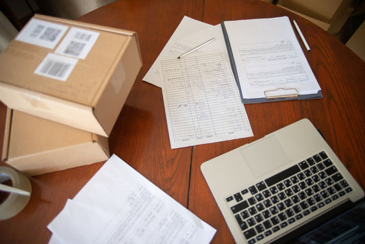 Office paperwork on a desk with a laptop
