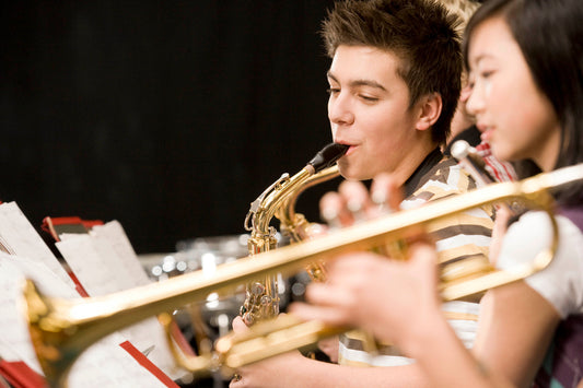 Teen boy and girl playing sax and trumpet