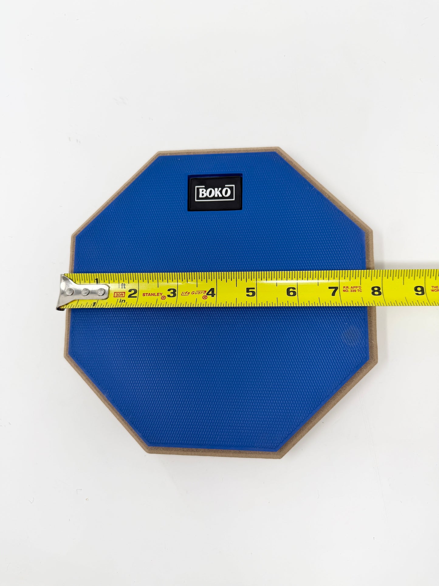 BOKO drum practice pad shown with a tape measure indicating size